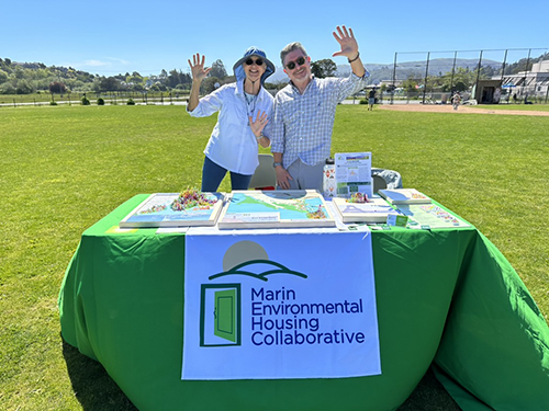 MEHC Board Members, Paul Jensen and Gail Napell tabling at Mill Valley Earth Day 2024. Table set up population density maps of Marin, New York, and Paris.